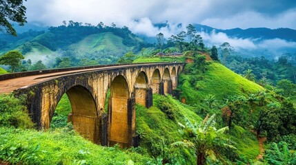 A scenic view of a nine-arch bridge in Sri Lanka with lush green foliage and a misty mountain backdrop.