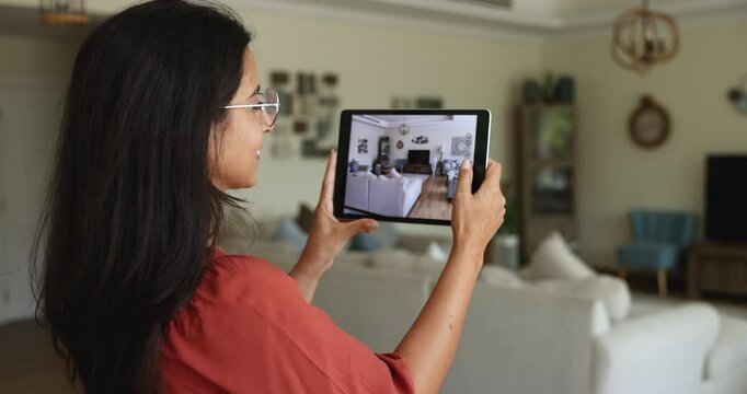 Side view young woman holds tablet, take pictures or videos of living room on device camera, capturing interior, make images for remodelling services, of, scanning space for home decor ideas using app