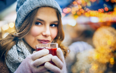 Woman enjoying hot punch at a Christmas market