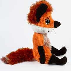 Amigurumi doll fox red background white isolated