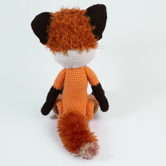 Amigurumi doll fox red background white isolated