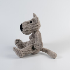Amigurumi doll wolf gray sits there white isolated