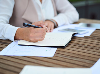 Book, hands and person writing notes in office for planning schedule, agenda or calendar. Pen,...