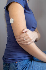 Girl sitting with sensor glucose patch on her arm