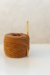 Brown lamb wool yarn and crochet hook. Natural