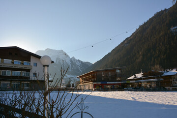 Wooden buildings of a large hotel complex with balconies are decorated. An example of architecture of winter recreation