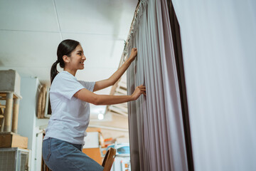 female asian production crew putting he curtain on the hanger to setting the wave while working at...