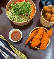 mozzarella cheese and fried chicken breast next to vitamin salad served on the sloe in a restaurant