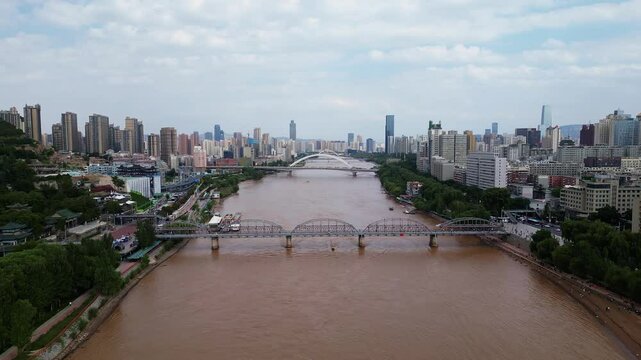 Lanzhou, China: Aerial drone footage of a speed boat sailing on the Yellow river under the Zhongshan bridge in Lanzhou, the main city of Gansu province in China. 