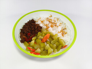 Minced black pepper beef, stir-fried chayote mixed with chopped carrots, served with steamed rice topped with crispy fried shallots, on a plate with green accents, against a white background