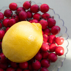 Yellow lemon and  berries in a transparent plate