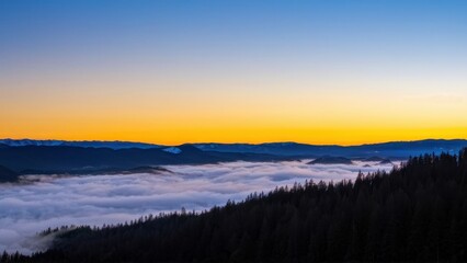 Fototapeta premium A serene sunset over a sea of clouds, with mountains in the distance.