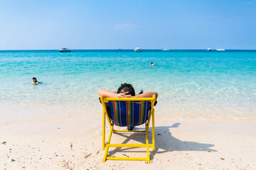 Chonburi, Thailand - February, 04, 2023 : Man Enjoying a Peaceful Day on a Beach Chair at Chonburi, Thailand.