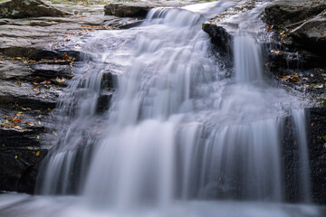 Obraz premium A waterfall is flowing down a rocky cliff