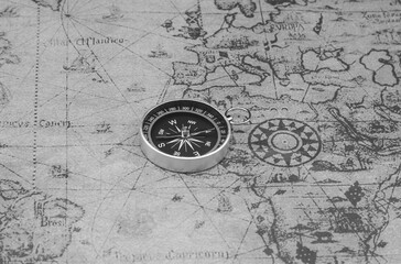 Classic round compass on background of old vintage map of world