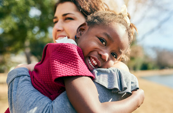Hug, love and adoption with interracial family in nature for foster care, bonding and support. Child welfare, placement success and security with mother and girl in outdoors for happiness together