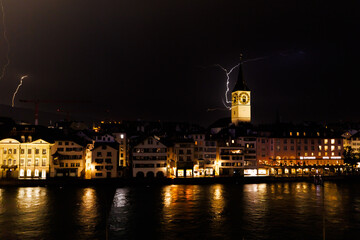 Thunderstorm over Zurich's old town at night; violent lightning behind church tower