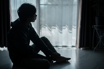 Silhouette of lost cast long shadow, embodying deep despair and hopelessness left him feeling perpetually stressed, sad, and unhappy. man sat alone, feeling weight of anxiety, stress, and depression.