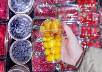 buying fruits and  berries ( raspberries, blueberries, strawberries, gooseberries)at the market