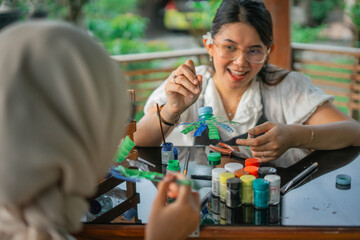 asian women enjoy making handmade craft from plastic bottle waste