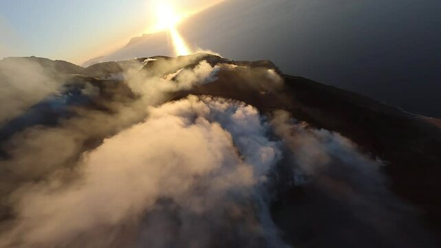 FPV drone fly through dust and smoke of Stromboli volcano eruption during sunset