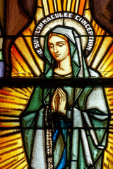 Fototapeta premium 2024-08-01, Paris, FRANCE. Stained glass of Apparition of the Virgin Mary, Our Lady of Lourdes or Notre Dame de Lourdes to Bernadette Soubirous. .