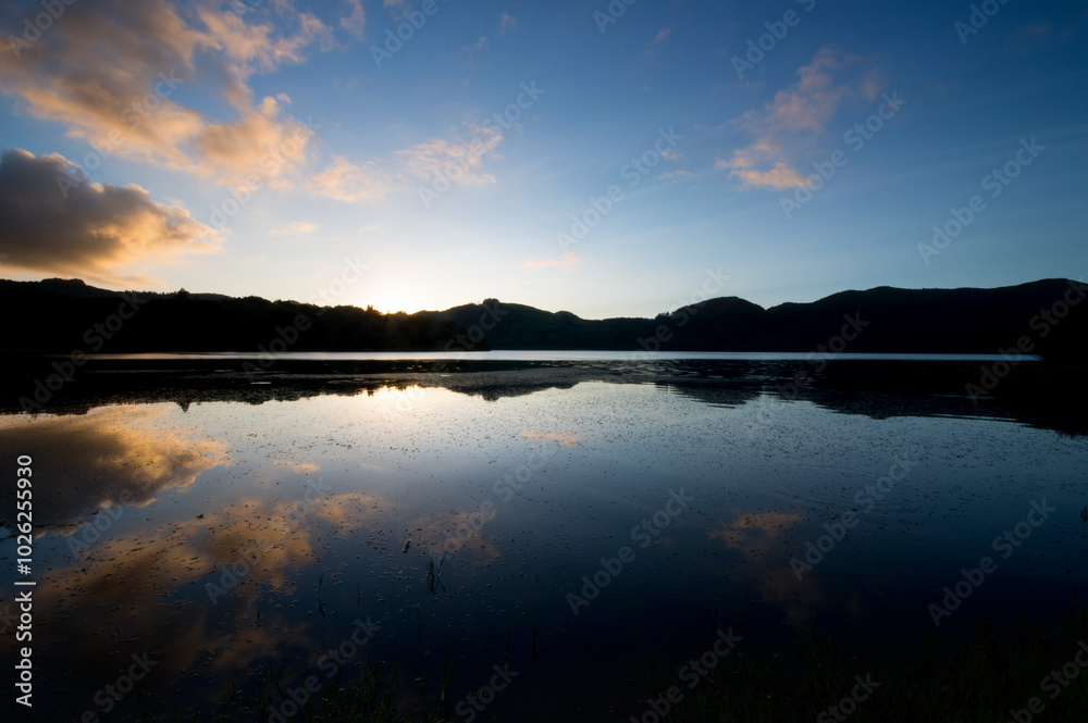 Wall mural sunset reflecting with blue hue in sete cidades volcanic lake in san miguel island in azores