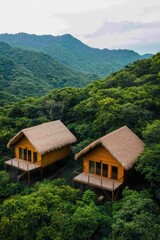 Obraz premium Two wooden houses nestled in lush green forest, surrounded by mountains.