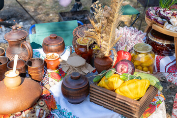 Street Ukrainian food festival. Clay dishes pot Bread on the table. Vegetables harvest autumn outdoor picnic