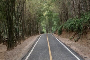 Curve of long road across through mountain view under cloudy sky