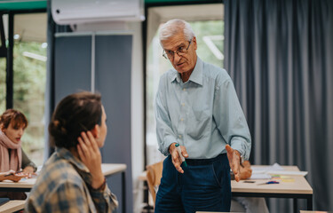 Fototapeta premium An elderly professor actively engages with students during a classroom session. The image depicts an interactive and attentive learning environment.