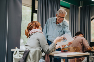 Obraz premium An experienced professor offers guidance to students in a classroom, creating an engaging and supportive learning environment. Education, mentorship, and collaboration are emphasized in this academic