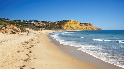 Summer beach with gentle waves meeting the shoreline under a clear blue sky, capturing the beauty of a perfect summer day.