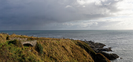 A small stone single arched Bridge on the track down to Old Portlethen Harbour and Salmon Fishing Bothy with Ships on the horizon.
