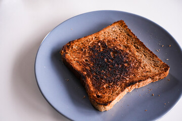 Burnt slice of toast bread isolated on white with text space