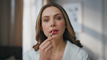 Pov lady applying lipstick looking at camera at home. Smiling woman lip care