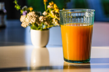 Fruit juice on the breakfast table in the morning sunlight