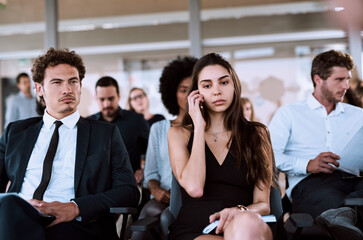 Obraz premium Business woman, diversity and phone call in communication, connection or networking in workplace. Group of people, employee engagement and mobile tech in conference, workshop or tradeshow as audience