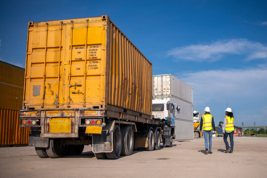 Engineer or worker team are standing forklift or truck vehicle are working appear discussing or reviewing document, likely related inspect container factory and industry transportation import export.