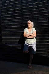 Cheerful gray-haired elderly woman on a dark background, low key.