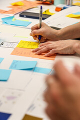 Collaborative Brainstorming with Sticky Notes. Close-up of hands actively participating in a...