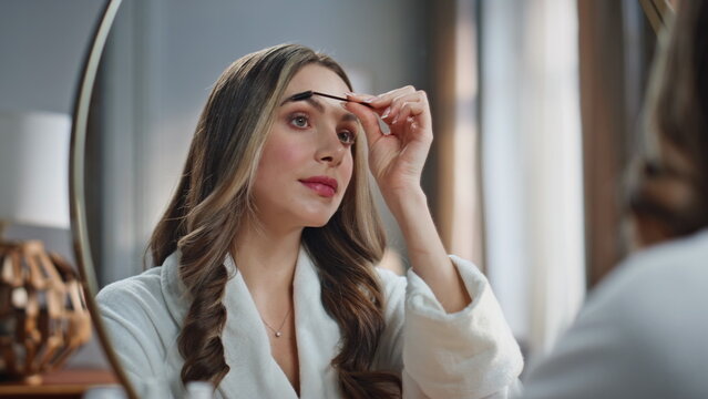 Morning woman combing brows with brush making shape closeup. Lady doing makeup