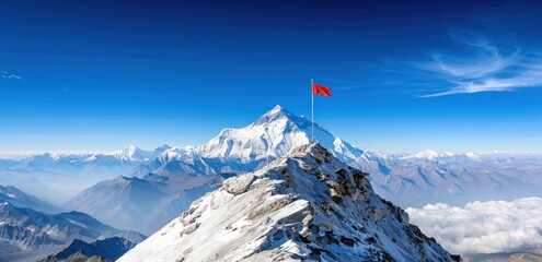 Red flag on snowy mountain peak with majestic clear blue sky