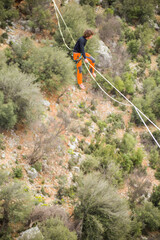 Obraz premium A tightrope walker walks along a cable stretched over a canyon.