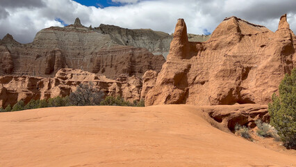 Fototapeta premium Scenic view of the stunning red rock formations and sand dunes at Kodachrome Basin State Park in Utah, USA. The dramatic landscape features towering sandstone cliffs and unique rock formations.