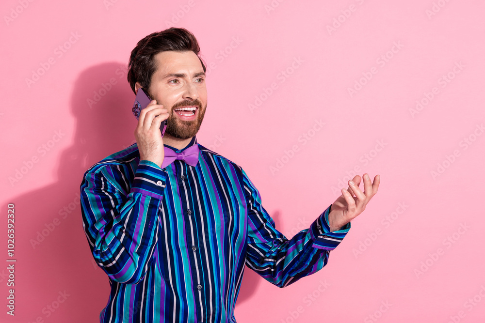 Poster Photo of attractive handsome elegant man wear trendy striped clothes talk phone empty space isolated on pink color background