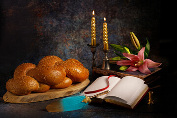 Challah (bread), Torah and candles on dark background. Traditional Jewish ritual of Shabbat....