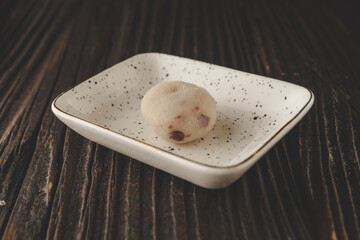 Japanese mochi on white plate with dark wooden background