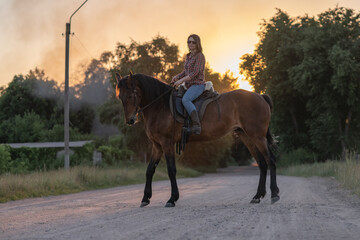 Portrait of a young beautiful dark-haired girl with a horse outdoors.