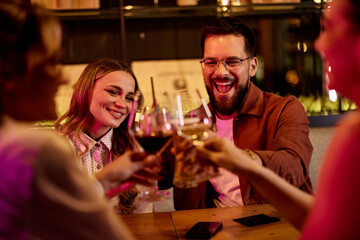 Friends Enjoying a Celebratory Toast in a Lively Restaurant Setting